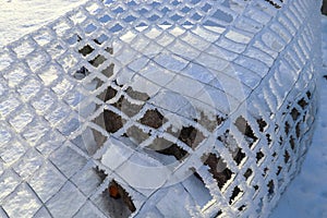 A fallen chain-link fence covered with rime ice