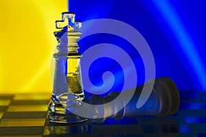Fallen chess king as a metaphor for fall from power ukrainian flag background copy space macro
