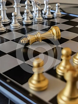 Fallen golden King chess piece