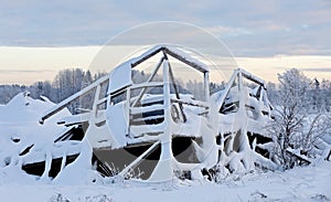 Fallen old barn in snowy winter landscape