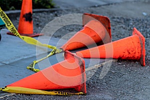 Fallen orange traffic cones and caution tape