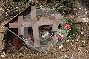 Fallen orthodox cross on an unmarked grave.