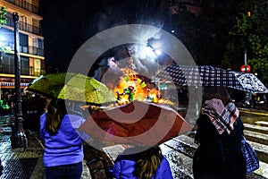 Falleros Valencians the night of San Jose contemplating as it disappears burned his Falla by the flames while it rains and use photo