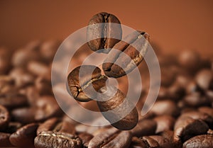 Falling aromatic roasted coffee beans, closeup view