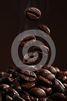 Falling coffee beans in hot steam close-up