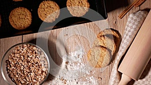 Falling cornflakes. Fresh baked cookies on baking tray. Dough roll and scattered flour.