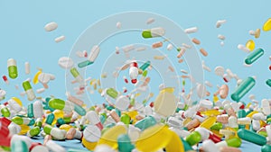 Falling different colored tablets, capsules on blue background. Health care concept. Antibiotics inside pills, vitamins