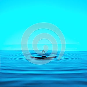 a falling drop and diverging circles on the water on a blue background