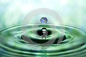 Falling drop of water with blue earth image