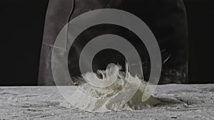 Falling egg into pile of flour on a black background. Process of preparing dough for homemade pasta. Slow motion, Full