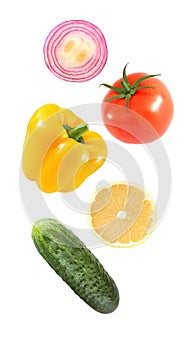 Falling flying vegetables bell pepper, onion, lemon, cucumber, tomato isolated on white background with clipping path