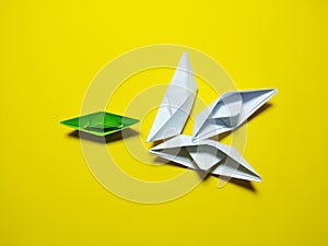 Falling green white paper boat The yellow background gives the concept of leadership and ineffective management. causing failure