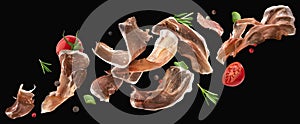 Falling jamon slices, iberian ham isolated on black background photo