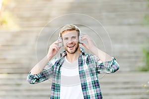 Falling in love with my headphones. Happy guy wear headphones outdoors. Handsome man listen to music in headphones. New