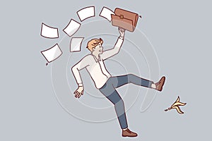 Falling man office employee slipped on banana peel and scattered documents from briefcase