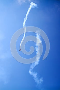 Falling plane on blue sky  background high in the sky, falls down, figure aerobatics The Barrel roll