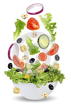Falling salad in bowl with lettuce, tomatoes, onion and olives
