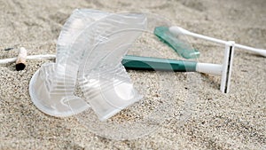 Falling sea garbage,cotton swabs,razor blade and cigarettes discarded on beach