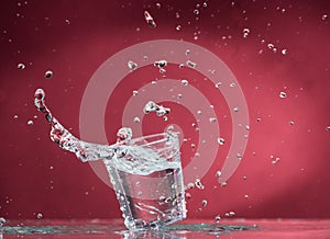 Falling small glasses and spilling water on a blue background