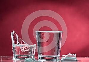 Falling small glasses and spilling water on a blue background