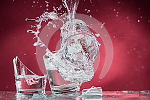 Falling small glasses and spilling water on a blue background