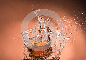 Falling small glasses and spilling water on a green background