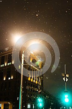 falling snow illuminated by light of street lamp