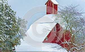 Falling Snow piles on roof of red barn