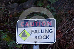 Falling stone warning traffic sign on the road