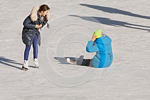 Falling teenager on the ice rink