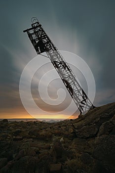 Falling tower against sunrise clouds, long exposure