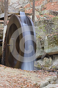 Falling water makes waterwheel spin photo