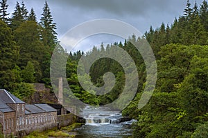 Falls and Old Mill Buildings Surrounded by Forest on the River Clyde in Scotland