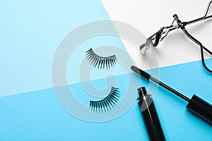 False eyelashes, curler and mascara on color background