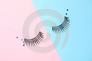 False eyelashes and sparkles on color background