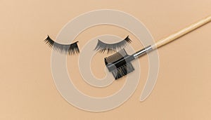 False eyelashes and a special comb on a beige background