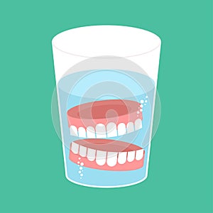 False teeth in glass. False jaw in glass beaker