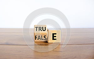 False or true symbol. Turned a wooden cube and changed the word `false` to `true` or vice versa. Beautiful wooden table, white