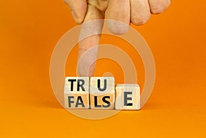 False or true symbol. Turned wooden cubes and changed the word false to true or vice versa. Beautiful orange table, orange