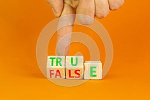 False or true symbol. Turned wooden cubes and changed the word false to true or vice versa. Beautiful orange table, orange