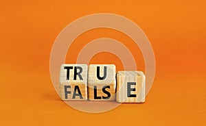 False or true symbol. Turned wooden cubes and changed the word false to true or vice versa. Beautiful orange table, orange