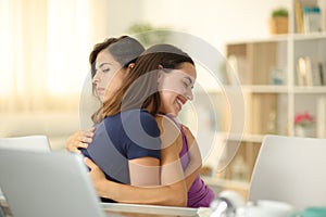 False woman hugging a friend at home