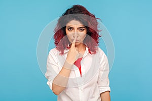 Falsehood sign. Portrait of angry displeased woman with fancy red hair in white shirt touching nose with lie gesture photo