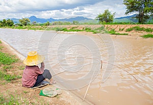 Famer fishing beside river in Northern Thailand