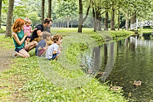 Families with children close to a waterscape with duck on it