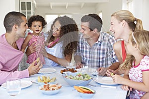 Families Enjoying Meal Together At Home