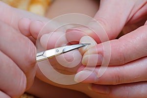 Family activity mother hand cut nails for kid by using nail scissors