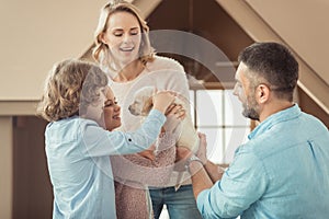 family with adorable labrador puppy in front of