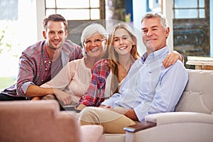 Family With Adult Children Relaxing On Sofa At Home Together