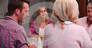 Family With Adult Offspring Enjoying Meal At Home Together